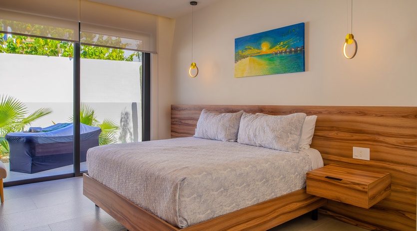 Rest peacefully in your serene bedroom with warm wood accents, modern pendant lighting, and garden views through floor-to-ceiling windows.