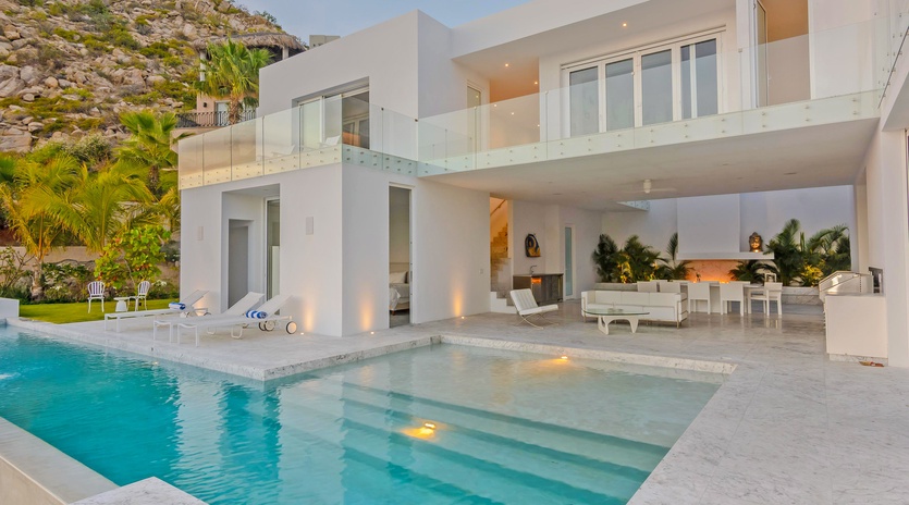 Modern villa with infinity pool seamlessly blending luxury and coastal landscape in an exclusive hillside setting.