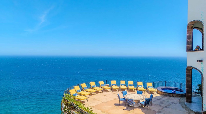 Imagine lounging on your private sun terrace with endless blue ocean views. This Mediterranean-style patio offers comfortable seating, a dining table for al fresco meals, and the soothing sound of waves below.