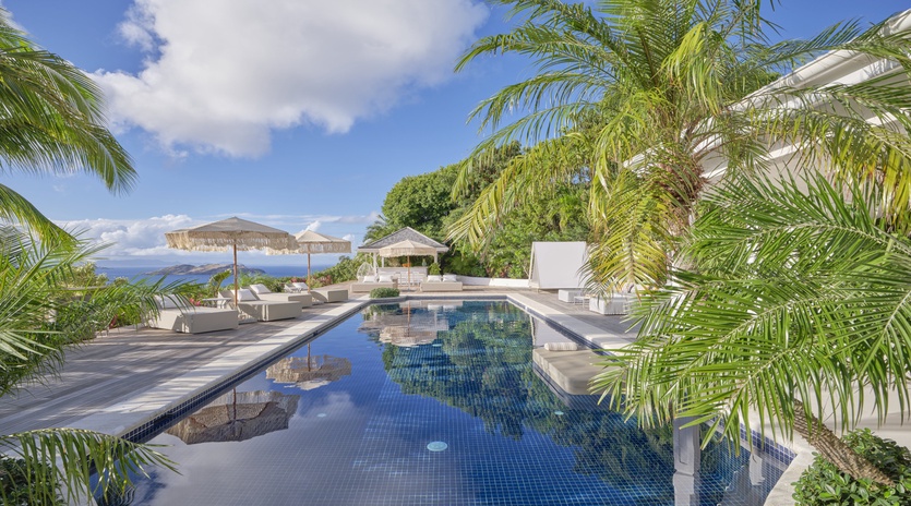 Your private paradise awaits with this stunning infinity pool surrounded by swaying palms and ocean views.