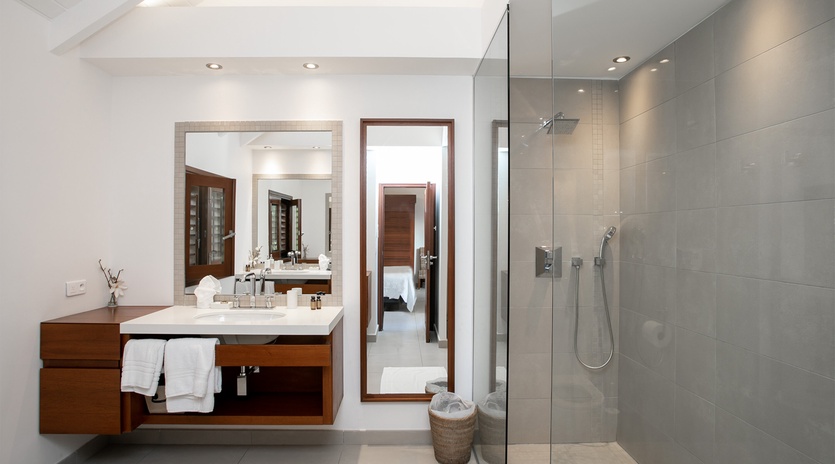 Step into your private spa-like retreat, where sleek gray tiles and warm wood tones create a peaceful sanctuary for your daily refresh.