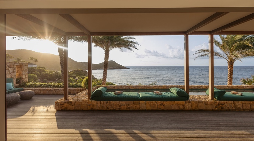 Relax on your private covered terrace with stunning ocean views and comfortable seating overlooking swaying palms.