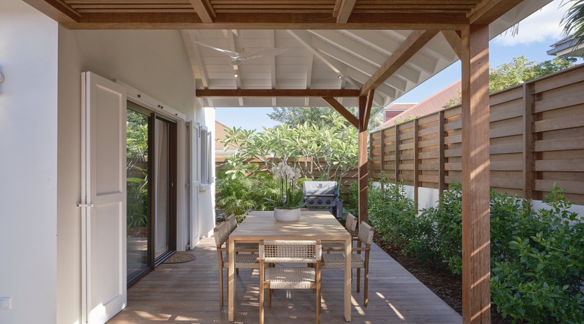 Your private terrace invites relaxed dining under dappled sunlight, where natural wood and tropical greenery create the perfect outdoor retreat.