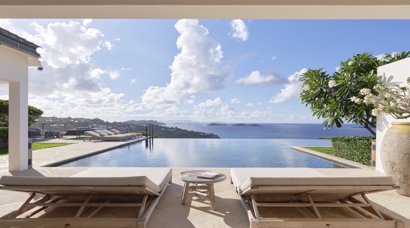 Recline on your private pool deck where an infinity edge meets endless ocean vistas, perfect for sun-soaked relaxation or quiet moments beneath dramatic tropical skies.
