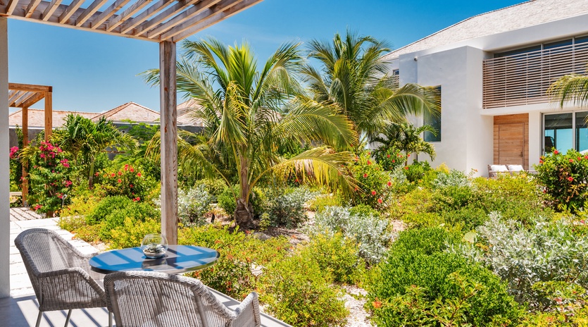Sip your morning coffee while gazing at lush tropical gardens framed by swaying palms and vibrant blooms from your private terrace.