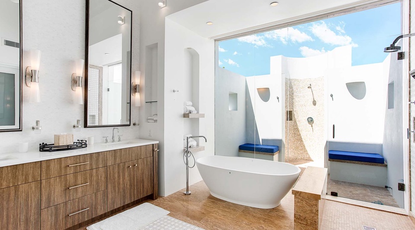 Soak in the freestanding tub while natural light pours in, or step through glass doors to your private outdoor shower with blue-tiled seating and open-air bliss.