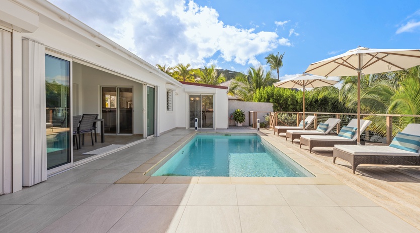 Your private poolside paradise awaits with crystal-clear waters, comfortable loungers, and tropical shade umbrellas.