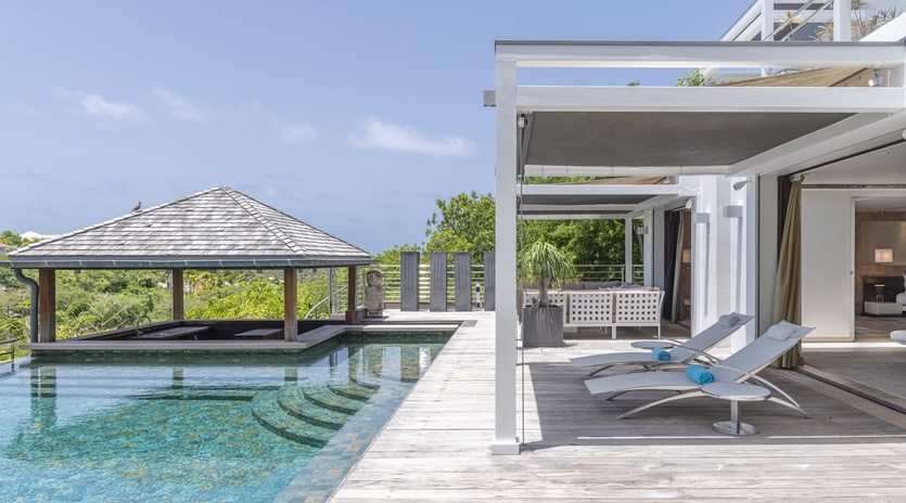 Bask in the sunshine on your private poolside deck, where sleek loungers and a shaded gazebo invite you to unwind in pure tropical luxury.