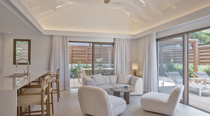 Unwind in your elegant living space featuring plush seating, designer ceiling, and seamless access to your private outdoor terrace.