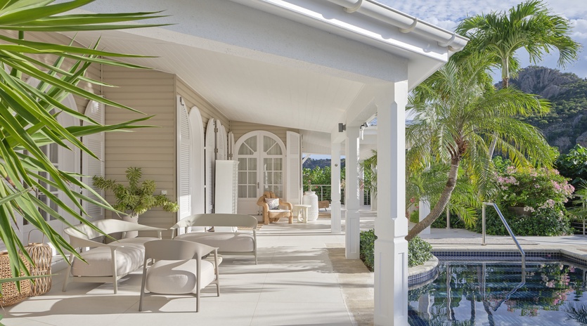 Relax on your private covered terrace with elegant white furniture, overlooking your pool surrounded by lush tropical gardens.