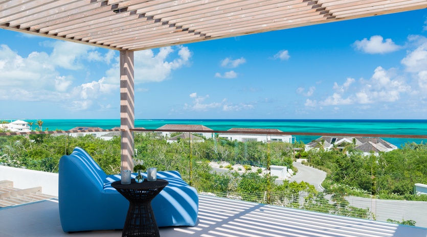 Relax in your private terrace seating as you soak in stunning turquoise ocean views through modern glass railings.