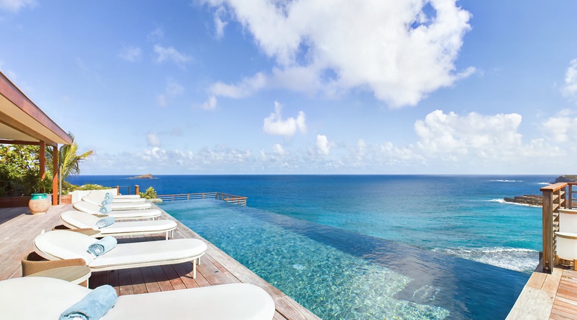 Stunning infinity pool deck with pristine ocean views and comfortable loungers for ultimate relaxation.