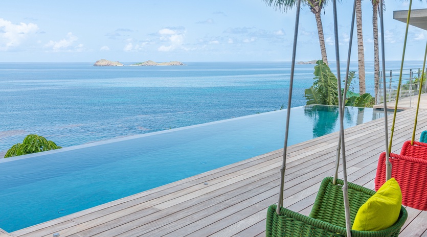Drift away in colorful hanging swings overlooking your infinity pool and endless ocean views with tropical palms swaying overhead.