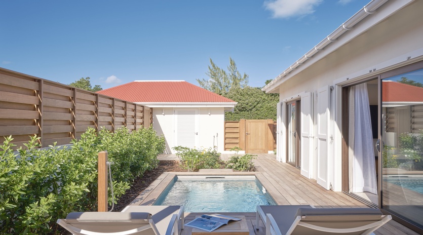 Step onto your private deck where a sparkling plunge pool awaits, surrounded by comfortable loungers and tropical greenery for ultimate relaxation.