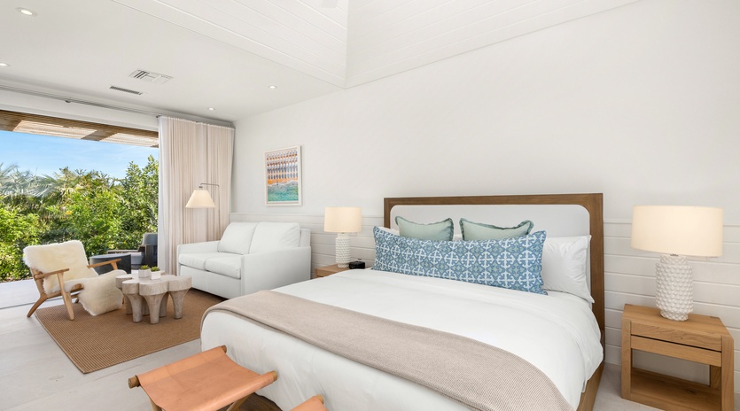 Unwind in your serene suite where soft linens meet tropical garden views through floor-to-ceiling windows.