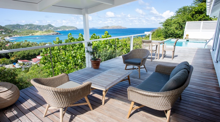 Relax in stylish wicker chairs on your private deck while soaking in breathtaking ocean views and tropical island scenery.