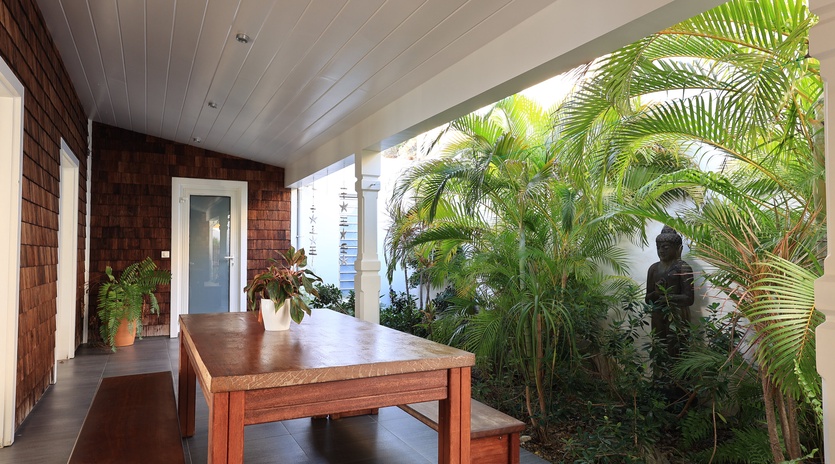 Relax on your private covered patio surrounded by lush tropical palms and peaceful garden views.