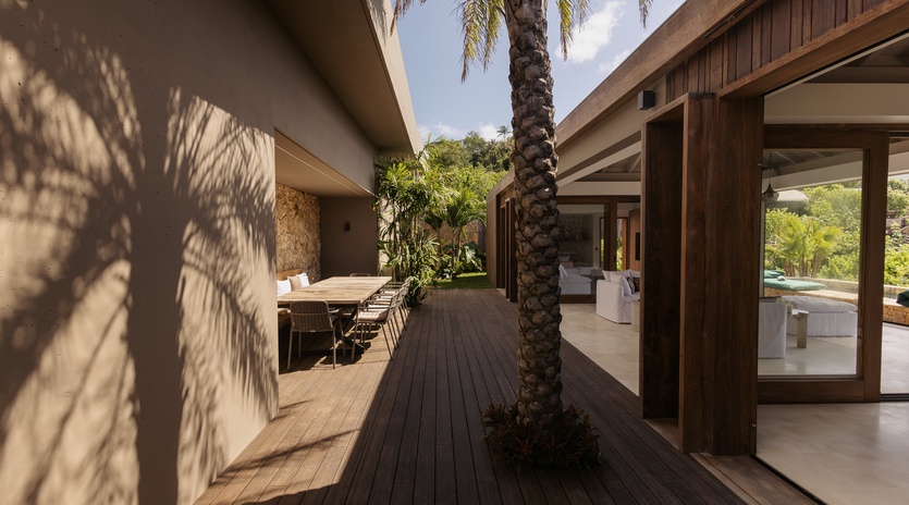 Modern architectural design features natural materials and tropical landscaping in this contemporary vacation property setting.