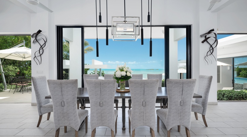 A stunning dining space that opens seamlessly to turquoise waters and endless sky. Gather with loved ones around this elegant table while ocean breezes drift through and natural light fills the room.