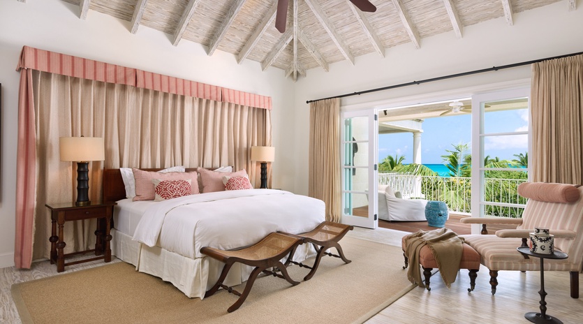 Your tropical sanctuary features a king bed, vaulted ceilings, and doors that open to a stunning turquoise sea view—perfect for relaxing mornings in paradise.