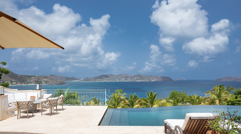 Infinity pool terrace with pristine ocean views stretching to distant islands, where your days are spent lounging poolside under Caribbean sunshine.