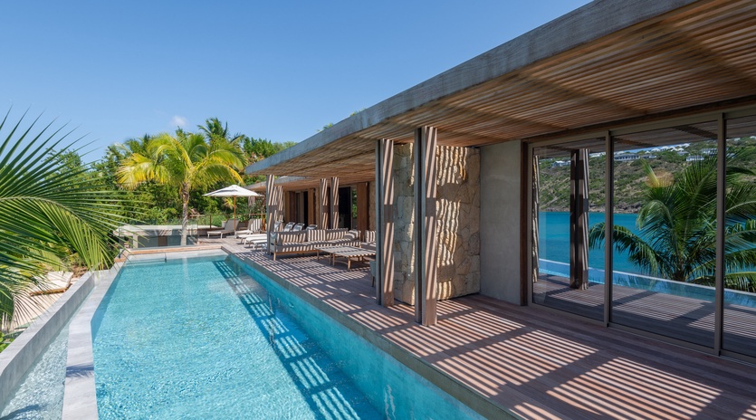 Sleek modern villa showcasing contemporary architecture with infinity pool and tropical surroundings in an exclusive hillside setting.