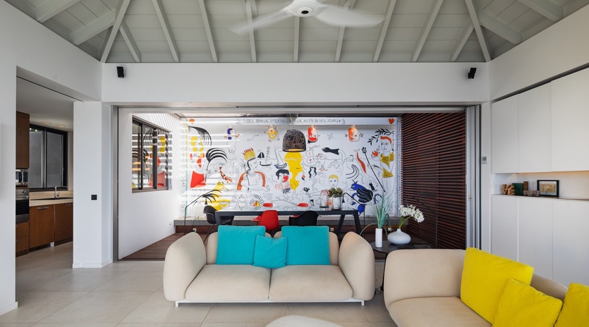Sink into the plush sofas in your open-plan living space, where a soaring cathedral ceiling and vibrant artwork set a playful, contemporary mood for relaxing and reconnecting.