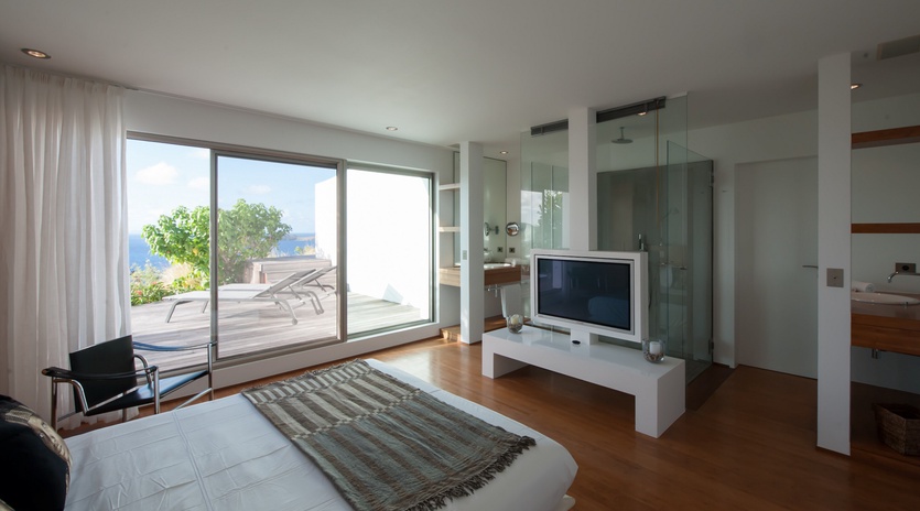 Wake up in your modern bedroom with floor-to-ceiling windows opening to a private terrace and stunning sea views.