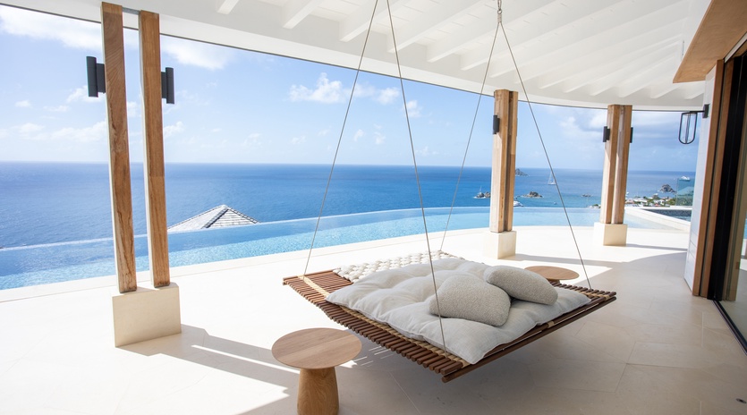Drift away on your private hanging daybed while gazing at endless ocean views through floor-to-ceiling windows.