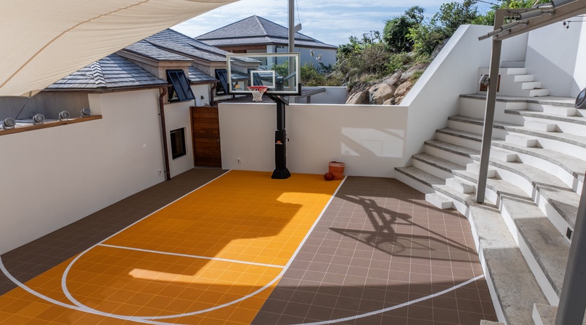 Your private basketball court awaits for friendly games under sunny skies, complete with professional hoop and vibrant court markings.