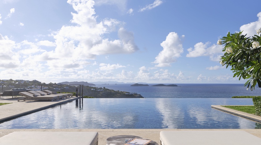 An infinity pool overlooking the shimmering Aegean and distant islands creates a serene oasis for your escape.