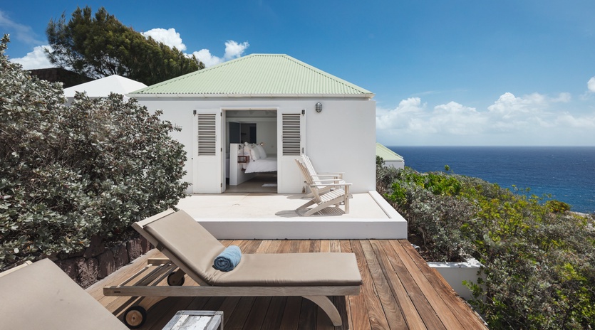 Stunning coastal retreat perched above crystal-blue waters. Relax on your private deck with ocean breezes, sunbathe on the loungers, and enjoy direct bedroom access to breathtaking sea views.