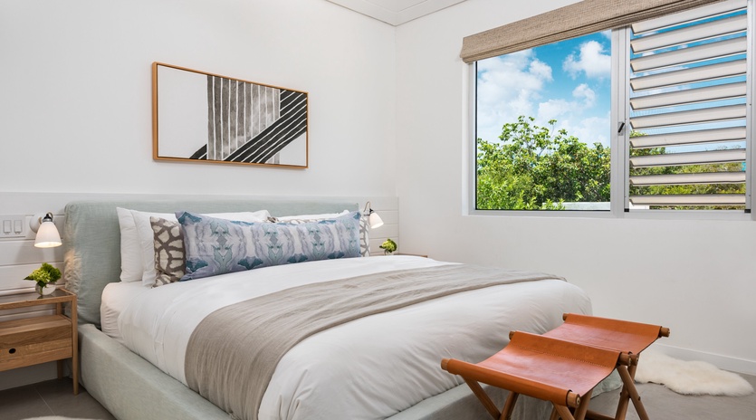 Rest peacefully in your bright bedroom with garden views through large windows and crisp white linens awaiting your arrival.