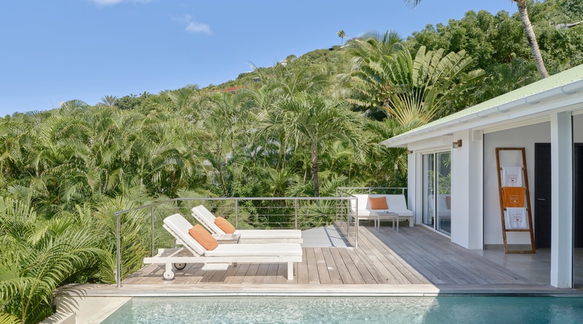 Your private pool deck awaits with sun loungers overlooking lush tropical gardens and rolling hillside views.