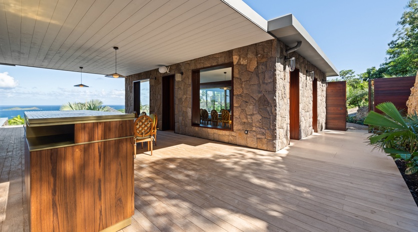 Modern stone and wood villa with ocean views, surrounded by tropical landscaping and contemporary design.