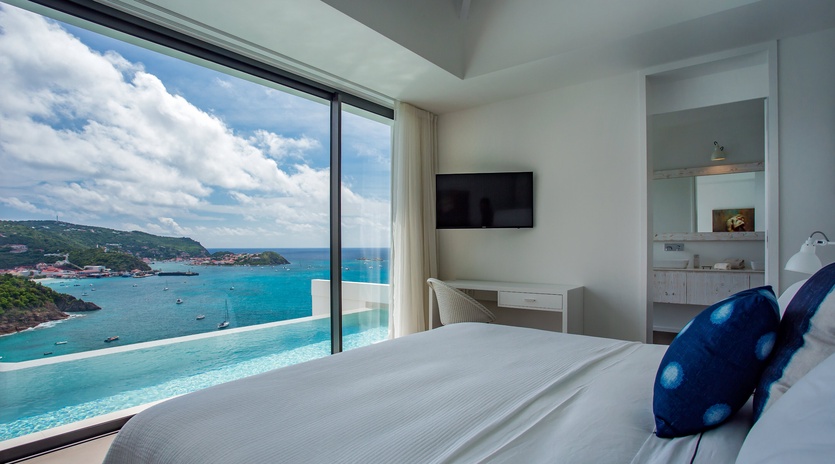 Wake up to breathtaking ocean views through floor-to-ceiling windows, where turquoise waters meet endless sky right from your bed.