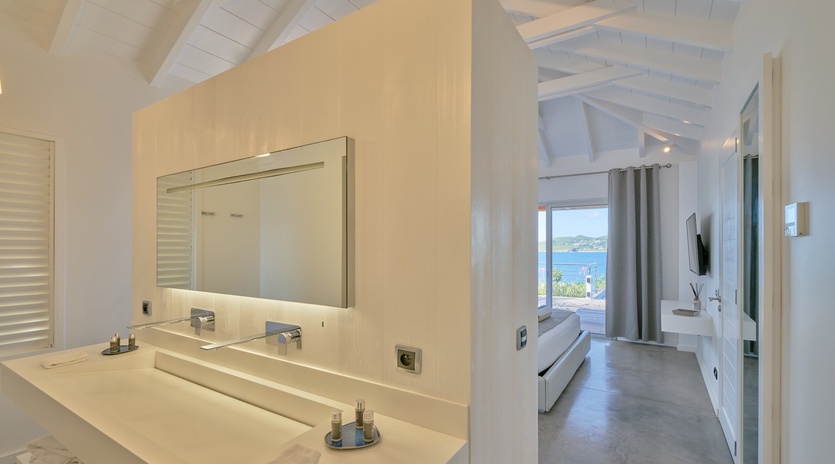 Your luxurious suite features a spa-like marble vanity and stunning sea views from your private bedroom, creating the perfect coastal retreat.