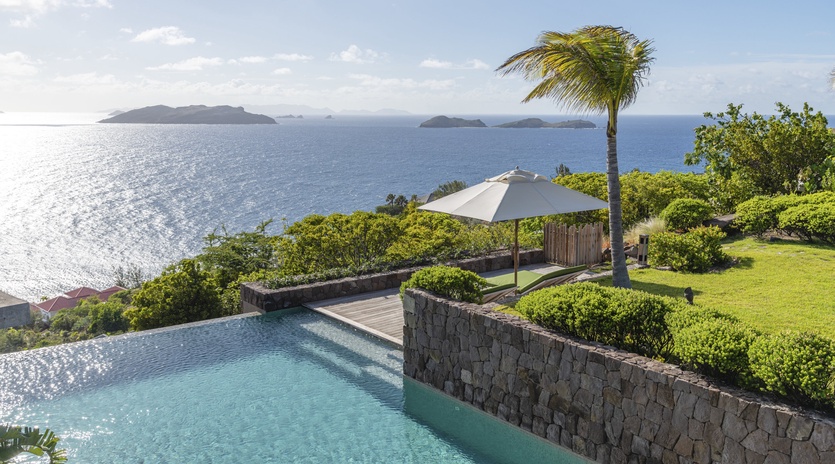 Stunning infinity pool overlooking crystal-clear Caribbean waters with tropical islands dotting the horizon.