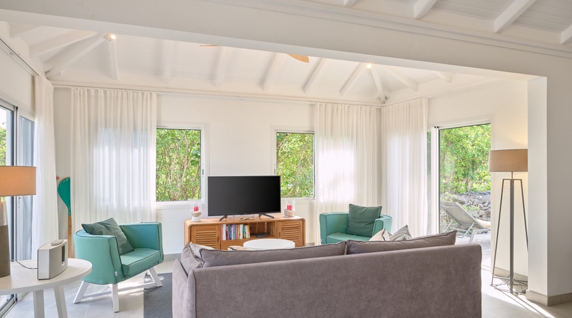 Unwind in your bright, airy living room where natural light streams through floor-to-ceiling windows, creating the perfect space for relaxation.