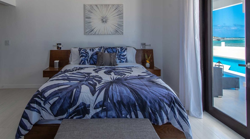 Wake up to turquoise waters and tropical breezes in your serene bedroom retreat. The stylish bedding invites restful sleep, while floor-to-ceiling windows frame stunning pool and beach views.