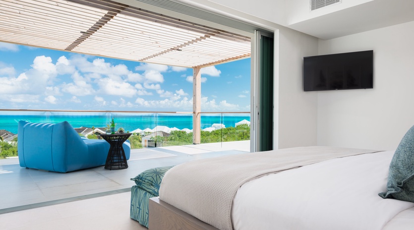 Wake up to stunning turquoise waters from your luxurious bedroom, where floor-to-ceiling windows frame breathtaking ocean views.