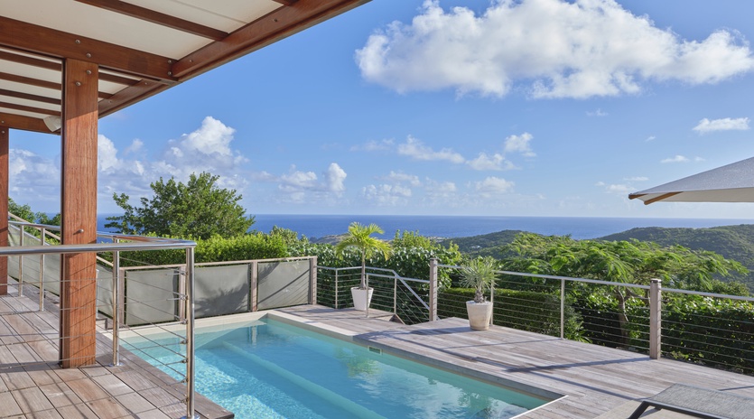 Dive into your private pool overlooking endless ocean and lush tropical hills—your perfect paradise retreat.