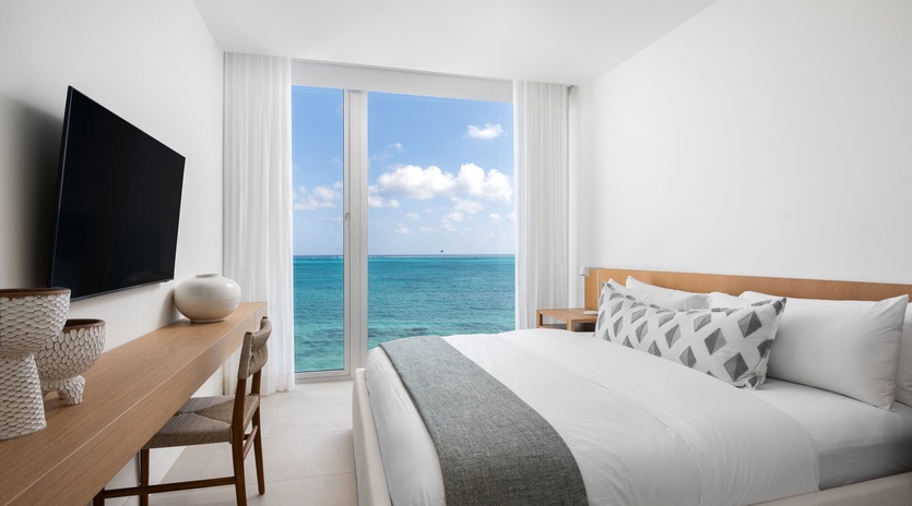 Wake up to endless ocean views from your comfortable bed, where floor-to-ceiling windows frame the turquoise sea perfectly.