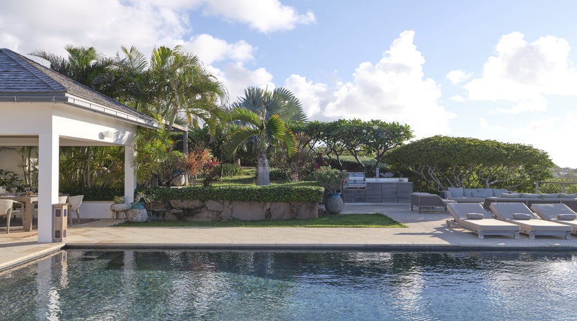 Settle into a sun lounger beside your sparkling pool, surrounded by lush tropical palms and open skies—perfect for lazy afternoons and warm island breezes.
