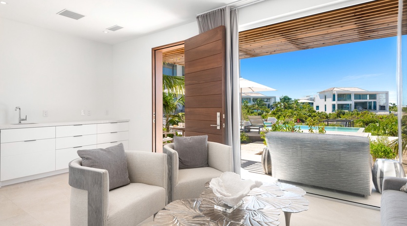 Relax in your elegant living space with sleek furnishings and stunning views of tropical gardens through expansive glass doors.