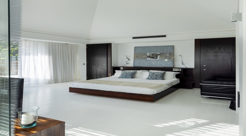 Unwind in your sleek, modern bedroom where minimalist design meets ultimate comfort—expansive windows flood the space with natural light.