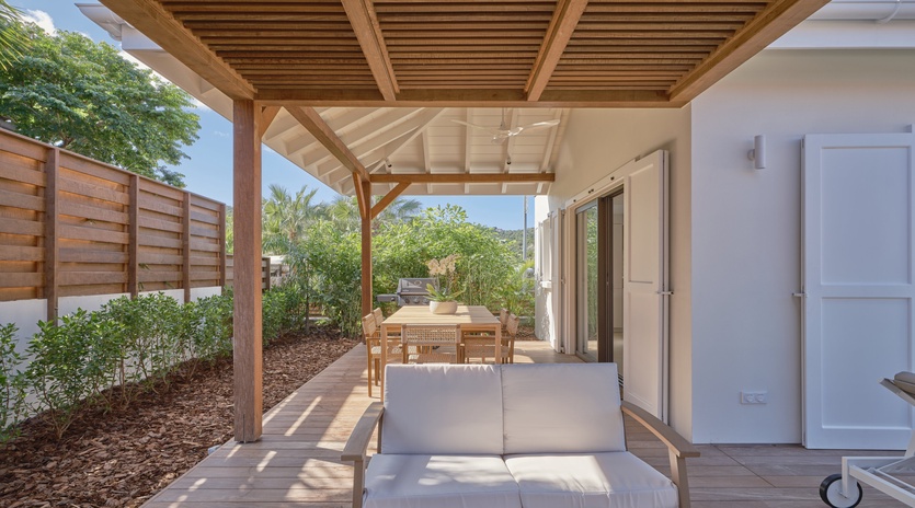 Unwind on your private terrace with comfortable seating under natural timber shade, perfect for peaceful moments overlooking lush gardens.