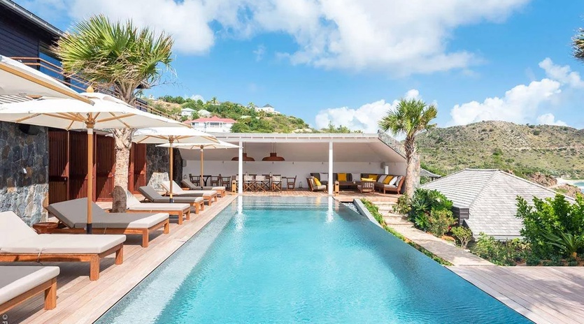 A stunning infinity pool framed by tropical palms and rolling hillsides, offering the perfect place to unwind and soak in the surrounding beauty during your island escape.