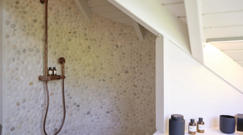 Unwind in your stylish shower with elegant penny tile and luxurious copper fixtures—your personal spa retreat awaits.
