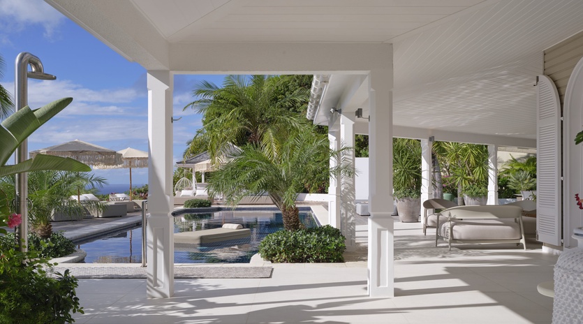 Tropical paradise awaits under your private covered terrace, where pool views and swaying palms create the perfect backdrop for relaxation.
